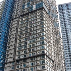 ADB Avenue Tower as seen from Guadix Drive cor. ADB Ave. on the sidewalk adjacent to the Asian Development Bank compound. It has a primarily white concrete facade making each unit distinguisable from outside.