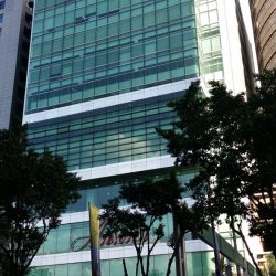 The Anson's Center in Ortigas Center is rectangular with a facade of green glass windows. There are segments of gray concrete that divides the floor, but the higher floors have fewer of these concrete segments and more of the glass surface. The word Anson's in red signage is between the second and the third concrete segment from the ground.