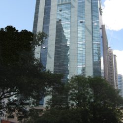 The upper floors of Antel 2000 Corporate Center have blue-green vertical bands of glass and concrete. This picture is from along Valero St. near the middle access to Valero Access Road.