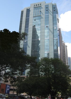 The upper floors of Antel 2000 Corporate Center have blue-green vertical bands of glass and concrete. This picture is from along Valero St. near the middle access to Valero Access Road.