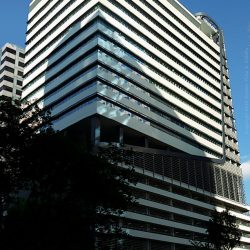 It is a high-rise building with an exterior of white horizontal bands of concrete. This picture was shot while standing across 3rd Avenue near the curved passage connecting it to Rizal Drive.