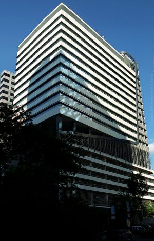 It is a high-rise building with an exterior of white horizontal bands of concrete. This picture was shot while standing across 3rd Avenue near the curved passage connecting it to Rizal Drive.