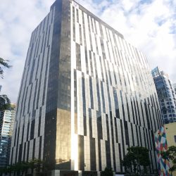 Bonifacio Stopover Corporate Center has a blocky structure and an exterior of vertical bands of black and white panels. This photo is as seen from the sidewalk of 32nd St. near the end of Kalayaan Flyover across Bonifacio Technology Center.