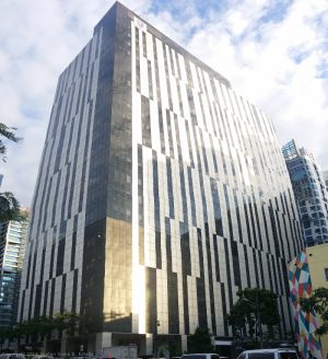 Bonifacio Stopover Corporate Center has a blocky structure and an exterior of vertical bands of black and white panels. This photo is as seen from the sidewalk of 32nd St. near the end of Kalayaan Flyover across Bonifacio Technology Center.