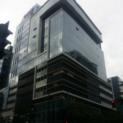 The Cocolight Building is a blocked-shaped midrise building. It has a glass surface and some white concrete highlights. The lower levels have darker glass panels or no glass at all, possibly parking areas. The upper parts have bluish glass panels. As seen from the side, the glass panels and white concrete lining seems to form a square bracket with extended top, and a short vertical rectangle in front of it, with the extended part of the bracket above the rectangle. The holes between the bracket and the rectangle are recessed sections of the wall. As seen in front, the blue glasses are continuous with a horizontal recess on second to the top floor.