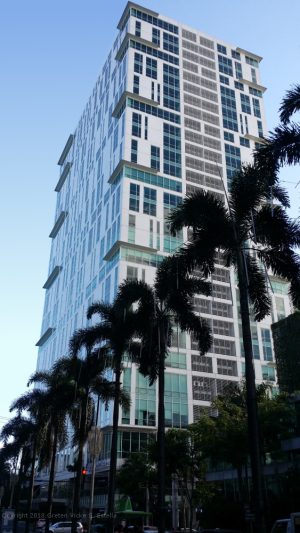 Cyberpark Tower One has a tall cuboid shape, with a surface of mostly white concrete with small blue-green glass windows. The shot was taken while on a pedestrian lane along Gen. Aguinaldo Ave. across Novotel Manila Araneta Center.