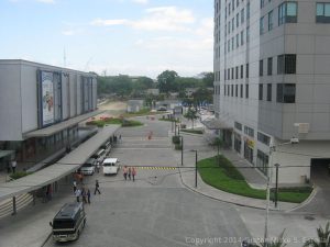 This photo is the driveway between Centris Sation and Cyberpod Centris. Centris Station is a mall situated at the corner of Quezon Ave. and EDSA; parts of it are visible on the left side of the picture. The taller building on the right side of the driveway is the Cyberpod One. This picture was taken from the northbound side of the MRT Quezon Avenue Station.