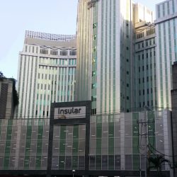 Back of Insular Life Building: the upper floors have a metallic gray facade of vertical strips with narrow windows between them. This is the view from Valero St. parallel to Valero Access Road 3 near Sedeño St.
