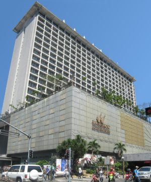 Manila Pavilion Hotel is an L-shaped building with gray concrete facade. This picture was taken from the opposite corner at the intersection of UN Ave. and Maria Y. Orosa St.