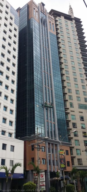 In this picture, the OMM-Citra Building is the building at the center with blue-green glasses for a facade. The main entrance has an arc on which OMM-Citra is embedded.