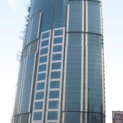 One Corporate Center has a facade of various sizes of blue glass panels and a roof that spirals upward. This photograph was taken from the open park under the flyover along Meralco Ave., north of Julia Vargas Ave.