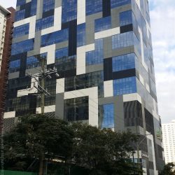 Panorama Building is a cuboid structure with patterns of gray, black, and white Tetris blocks. This picture was taken along 34th Street, a few steps away from its intersection with 5th Ave.
