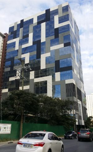 Panorama Building is a cuboid structure with patterns of gray, black, and white Tetris blocks. This picture was taken along 34th Street, a few steps away from its intersection with 5th Ave.