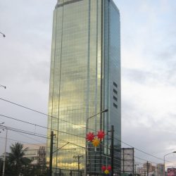 Blocky and glass-clad high-rise PET Plans Tower against a cloudy sky.