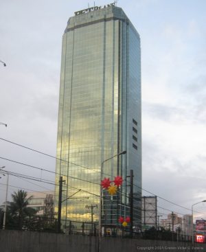 Blocky and glass-clad high-rise PET Plans Tower against a cloudy sky.