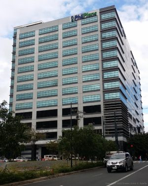 Total Corporate Center has a cuboid structure and concrete exterior with open windows on the lower floors and glass panels on the upper floors.