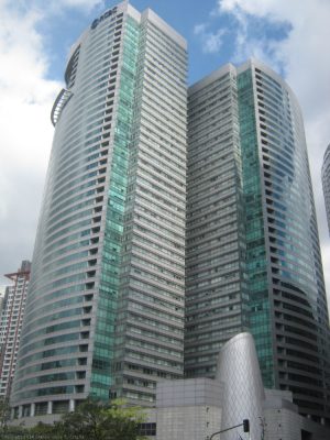 RCBC Plaza is a skyscraper complex that has two towers with alternating horizontal bands of gray tiles and reflective glasses mounted on a common podium structure. This is RCBC Plaza, seen from the sidewalk along Salcedo St. between Ayala and Dela Rosa.