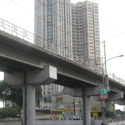 Modern building with a geometric facade, tiered corners, beige color, and blue windows.