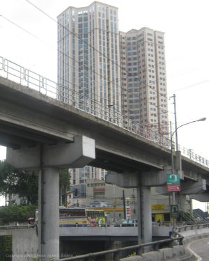 Modern building with a geometric facade, tiered corners, beige color, and blue windows.