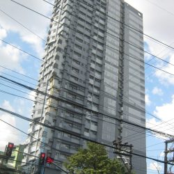 tall multi-story building with staggered facade and overhead power lines in the foreground.