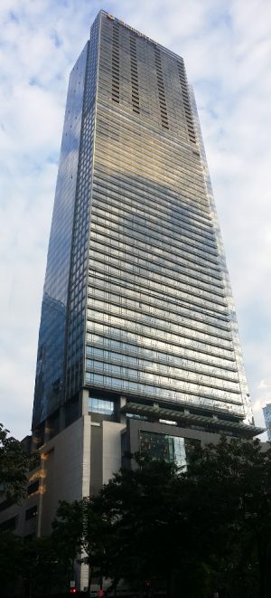 Shangri-La at the Fort has two parts, a podium with a concrete and glass window facade, and a tower with a uniform appearance of glass panels. This picture shows what you can see from along Rizal Drive on the opposite side of 30th St.