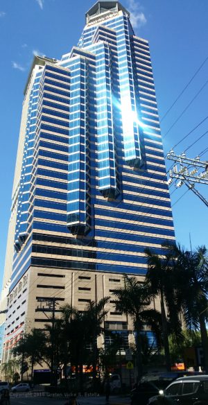 Union Bank Plaza is a bottle-like building with alternating bands of blue glass panels and beige concrete. This is the Union Bank Plaza, viewed from along Sapphire Road in front of Parc Chateau.