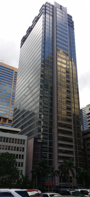 Wynsum Corporate Plaza is a tall and narrow rectangular prism covered with several panels of dark green glass. This picture was shot from the parking area between Prestige Tower and The Taipan Place.